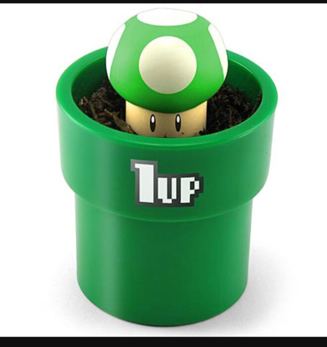 En grön och vit Super Mario-svamp figur placerad i en grön kruka med texten "1UP".