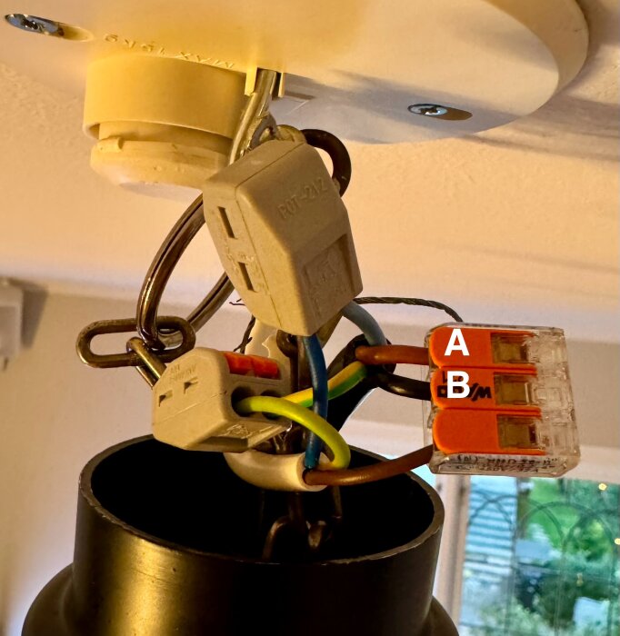 Ett kopplingsschema för en lampa med kablar märkta A och B, tillsammans med blå och gulgröna kablar.