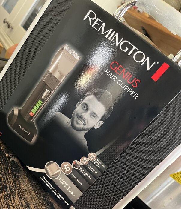 Förpackning av en Remington Genius hårklippare som visar apparatens bild, funktioner och specifikationer, inkl. batteritid och justerbara kammar.