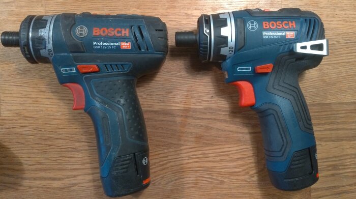 Två Bosch Professional GSR12V-15FC och GSR12V-35FC skruvdragare placerade på en träyta, båda i blå och svart färg med röda och orange detaljer.