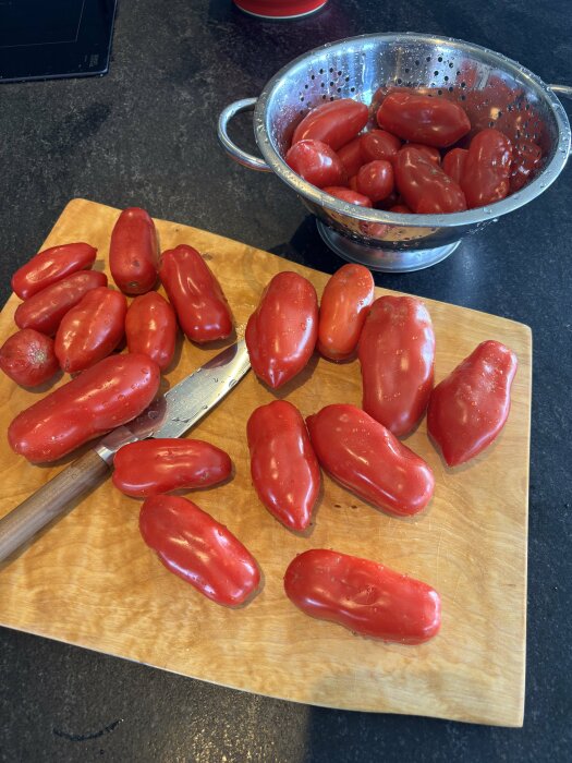 San Marzano-tomater på en skärbräda och i ett durkslag, redo att kokas till tomatsås för framtida pizzabak.