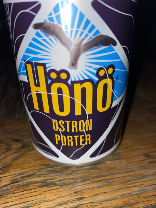 Närbild på en ölburk med etiketten "Hönö Ostron Porter" och en mås i bakgrunden.