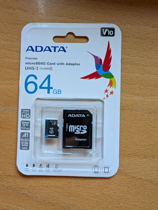 ADATA 64GB microSDXC Card med adapter, förpackad i blisterförpackning med en bild av en färgglad fågel.