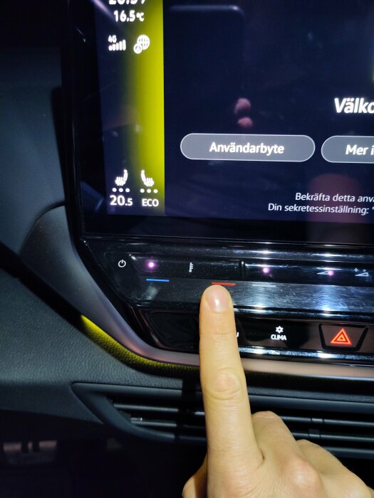 Person pekar med ett finger på en knapp på en pekskärm i en bil med inställningar för klimatanläggning och användarbyte.
