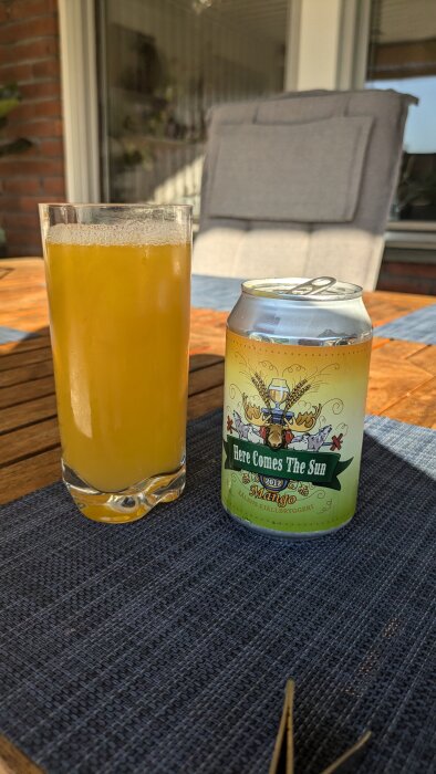 Ett glas med ljus öl och en öppnad burk "Here Comes The Sun" mangoöl från Sälen Fjällbryggerier på ett bord.