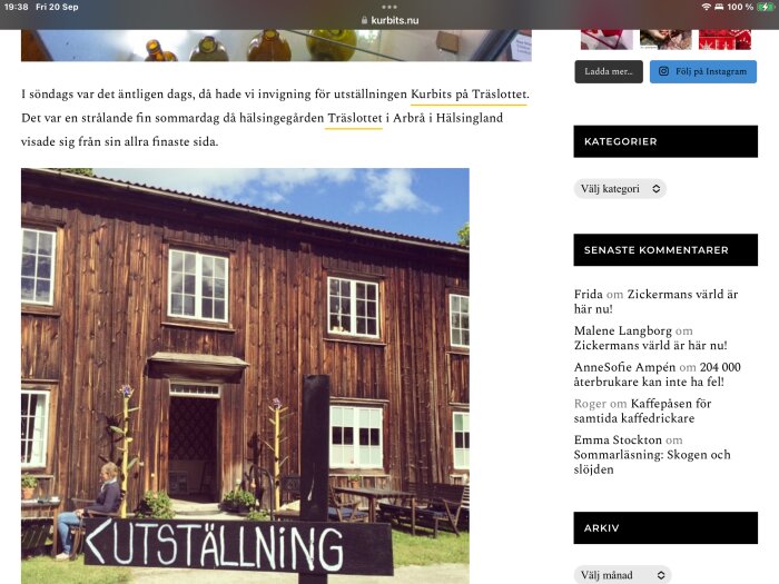 Bild på Träslottet i Arbrå, Hälsingland, ett träbyggt hus från 1700-talet. Utanför huset sitter en person och en skylt med texten "UTSTÄLLNING" är uppställd.