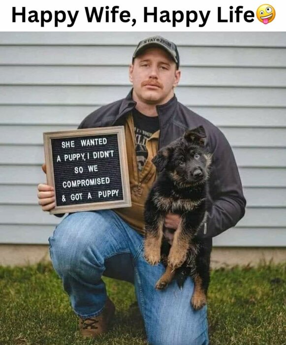 Man håller en liten valp och en skylt med texten "She wanted a puppy, I didn't, so we compromised & got a puppy", framför en husvägg. Texten "Happy Wife, Happy Life" överst.