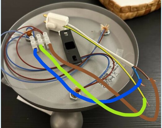 Närbild av elektriska kablar och kopplingar i ett takuttag med färgglada markeringar som visar hur kablarna ska kopplas. En stickpropp är ansluten.