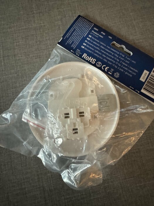 Förpackning med stickpropp till lampa, vit botten och blå etikett, synlig text anger specifikationer som 250V, 16A och ROHS-certifiering.