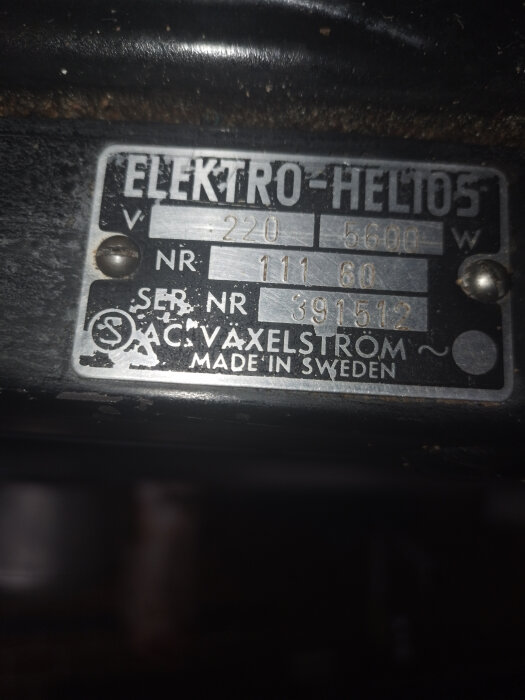 Skylt från Elektro-Helios med texten "220 V", "5600 W" och serienummer "391512", funnen under plattor. Texten "Made in Sweden" syns också.