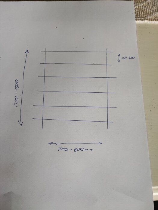 Ritad skiss på papper som visar måtten 700-800 mm på bredden och 1200-1500 mm på höjden, med linjer förvertikala hyllplan för skruvförvaring.