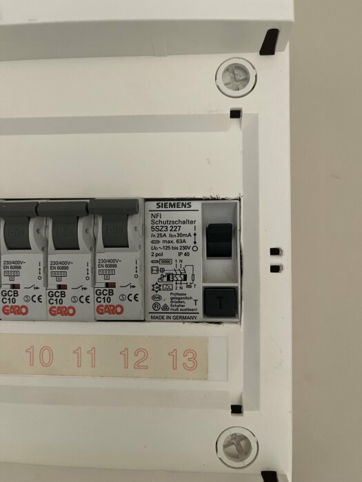 Närbild av ett proppskåp med nummer 10 till 13 och märkningar på strömbrytare, däribland en Siemens-brytare för 230V, 2 poler, 25A, 30mA.