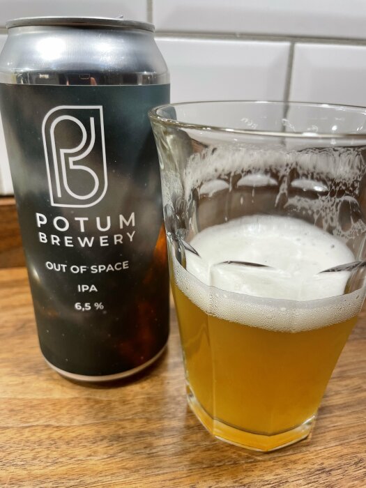 En ölburk från Potum Brewery med en IPA på 6,5 % alkohol, bredvid ett glas med samma öl.