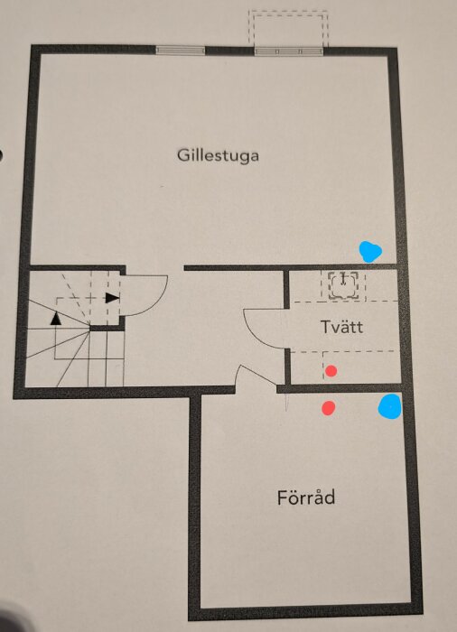 Planritning av källarvåning med utsedda områden för gillestuga, tvätt och förråd. Blå och röda markeringar indikerar ventilationspunkter.