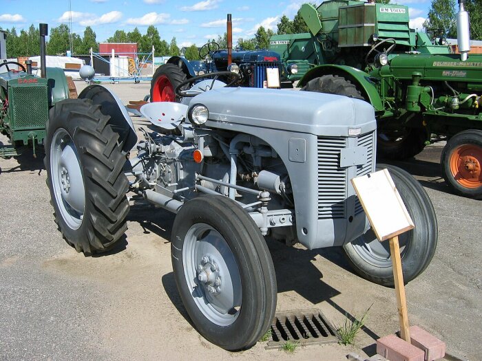 Grå Ferguson TEA/TED/TEF 20 traktor, även känd som "Grålle", parkerad utomhus bland andra traktorer på en utställning.