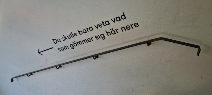 Text på vägg ovanför en trappräcke som säger "Du skulle bara veta vad som gömmer sig här nere" med en pil pekande nedåt.