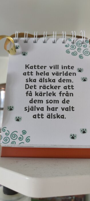 En bordskalender med ett citat om katter: "Katter vill inte att hela världen ska älska dem. Det räcker att få kärlek från dem som de själva har valt att älska.