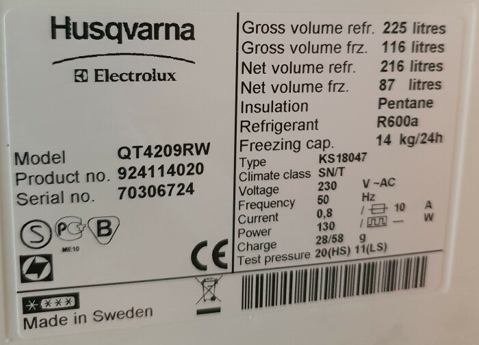 Etikett på äldre Husqvarna-Electrolux kyl/frys QT4209RW som visar modell, produktnummer, serienummer, kapaciteter, klimatklass, kylmedel, och andra specifikationer.