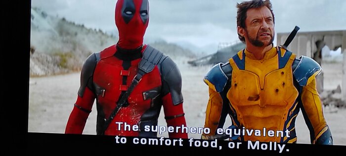 Deadpool och Wolverine står bredvid varandra, Deadpool i röd dräkt och Wolverine i gul rustning. Undertext: "The superhero equivalent to comfort food, or Molly.