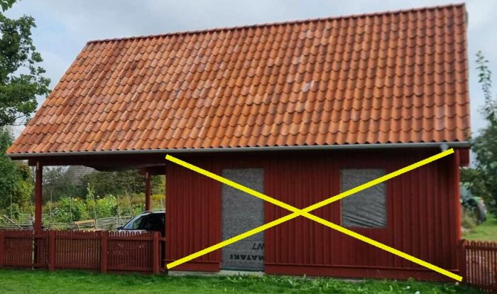 En röd byggnad med tegeltak och två avspärrade fönster, med gula diagonala linjer som bildar ett X över framsidan, visar förslag på tvärstadga.