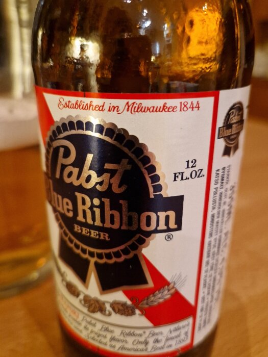 Flaska med Pabst Blue Ribbon-öl från USA, etiketten visar texten "Established in Milwaukee 1844" och innehåller 12 FL.OZ av öl.