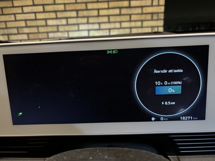 Bilens instrumentpanel visar batteriets laddstatus, 0% kvar och 10 timmars väntad laddtid, efter att ha kört med tomt släp, totalt 18271 km körsträcka.