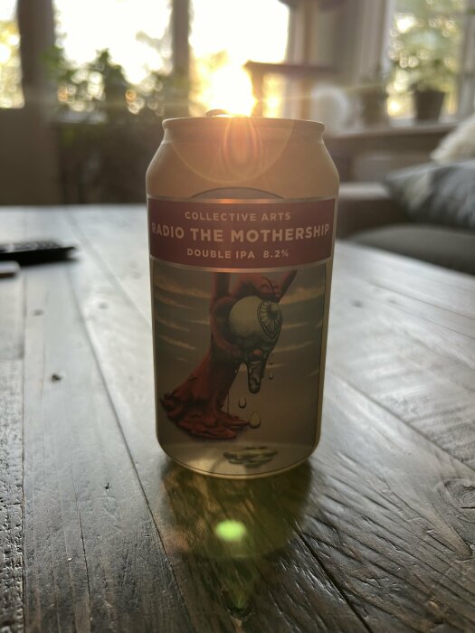 En burk av Collective Arts Radio the Mothership Double IPA 8.2% står på ett bord med solen i bakgrunden.