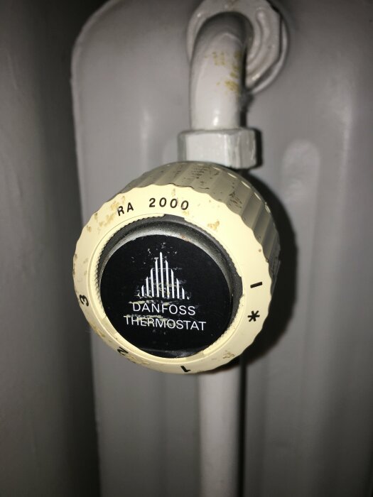 Danfoss termostat RA 2000 på ett element, nära en vit ventil.