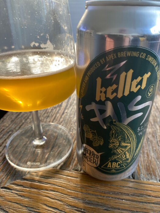 Keller Pils från Apex Brewing i glas och burk på träbord med ofiltrerad öl.