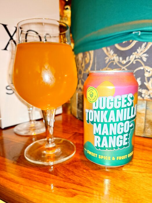 Dugges Tonkanilla Mango-range sour beer can and glass on a wooden table during after-work gathering.