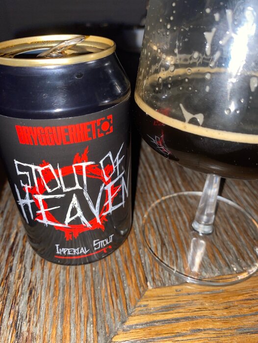 En burk Stout of Heaven imperial stout från Bryggverket och ett halvtom glas på ett träbord.