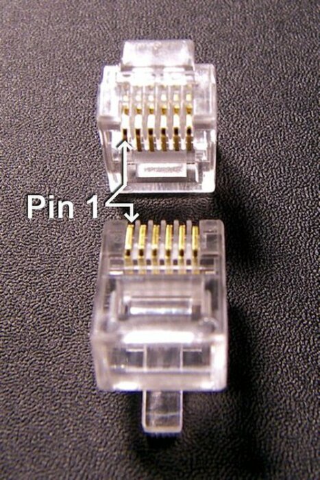 Två RJ12-kontakter där den övre har en pil markerad med "Pin 1".