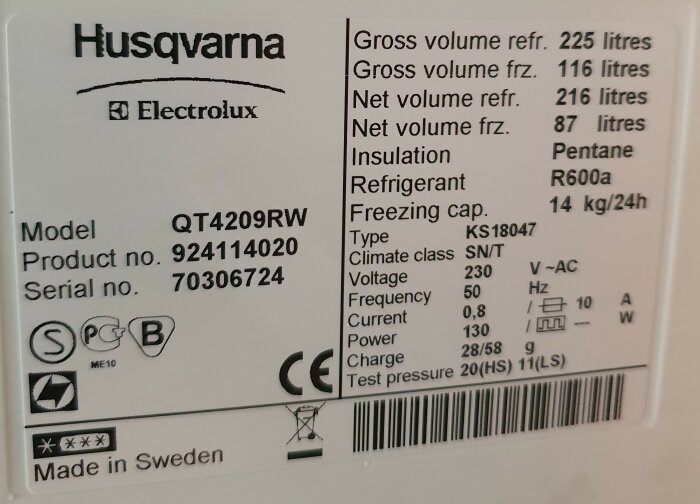 Kylskåpets informationsetikett från Electrolux modell QT4209RW med detaljer om volym, kylmedel och serienummer.