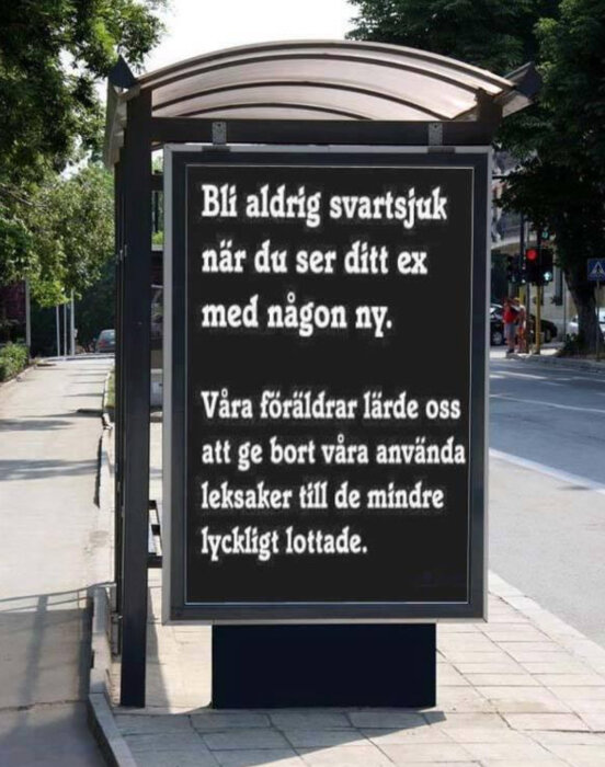 Reklamskylt vid gatan med text om att inte bli svartsjuk på ens ex, kopplad till en humoristisk lek om leksaker och lyckligt lottade barn.