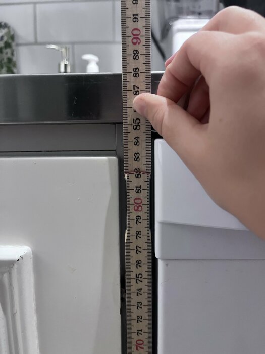 Mätband som visar 90 cm från golvet upp till diskbänken i ett kök.