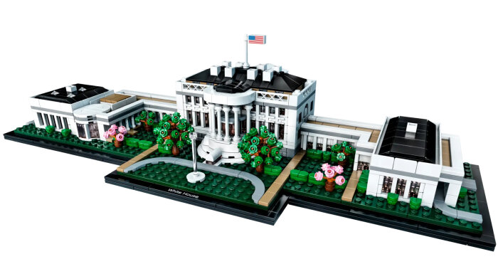 Lego-modell av Vita huset med detaljerade trädgårdar och en amerikansk flagga på taket.