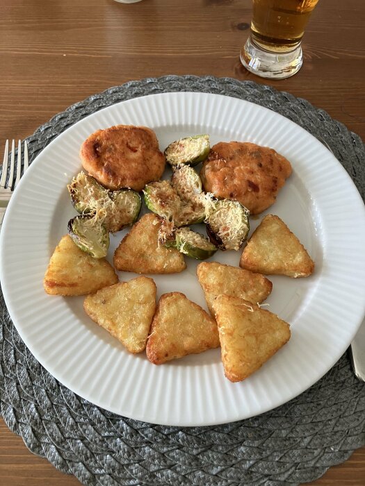 Tallrik med laxbit, triangelrösti och ugnsrostad brysselkål toppad med parmesanost.