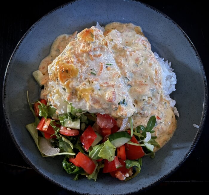 Krämig sweetchili-torsk serverad med ris och sallad på en tallrik.