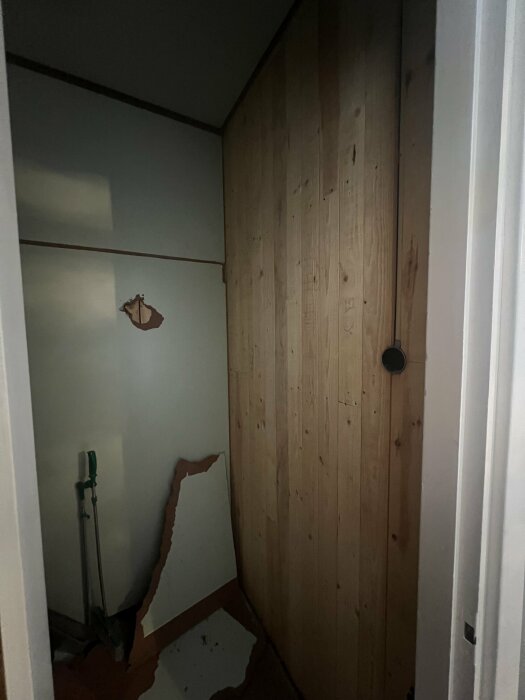 Bruten masonitskiva och träv�gg i en klädkammare under renovering i villa från 60-talet.