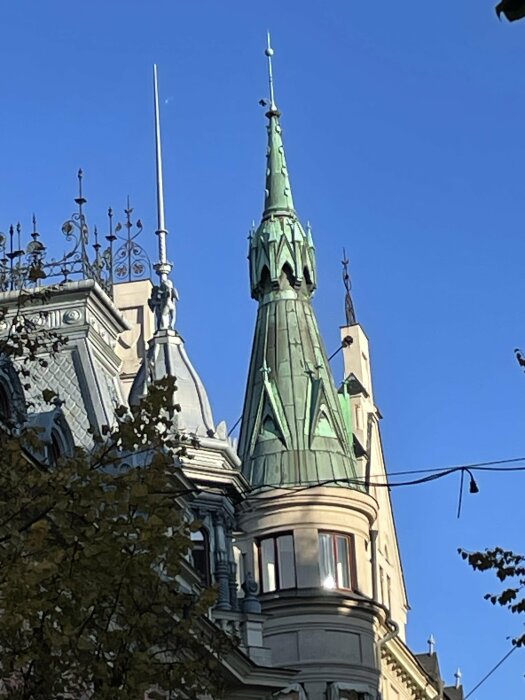 Torn och detaljerat tak på en historisk byggnad mot en klarblå himmel.