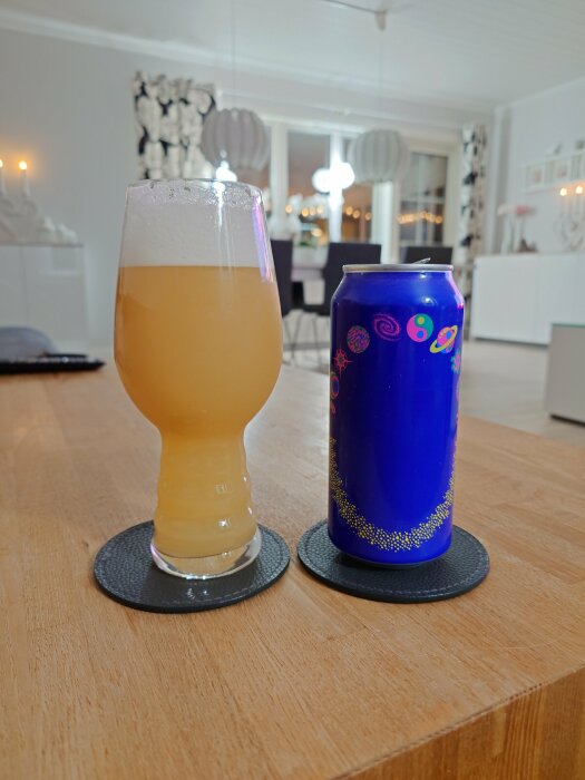 En burk Omnipollo Fatamorgana-öl bredvid ett glas med gyllene dryck och skum, placerade på ett bord i ett modernt inrett rum.