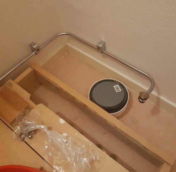 Träinstallation på golv med rör och hink, möjlig förberedelse för vatten och avlopp till WC.