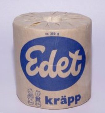 Edet toalettpappersrulle inpackad i papper, med en blå logotyp och texten "kräpp" på framsidan.