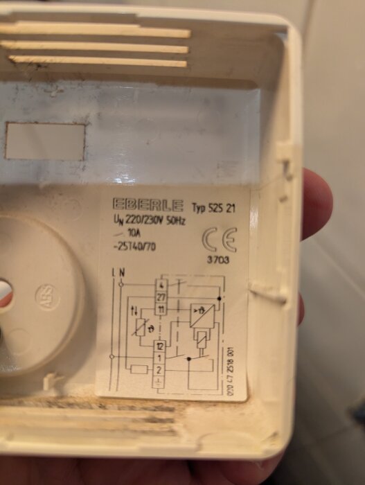 Vit Eberle termostat med modellbeteckning S25 21 och elektrisk schema, visas på insidan av en plastkapsling.