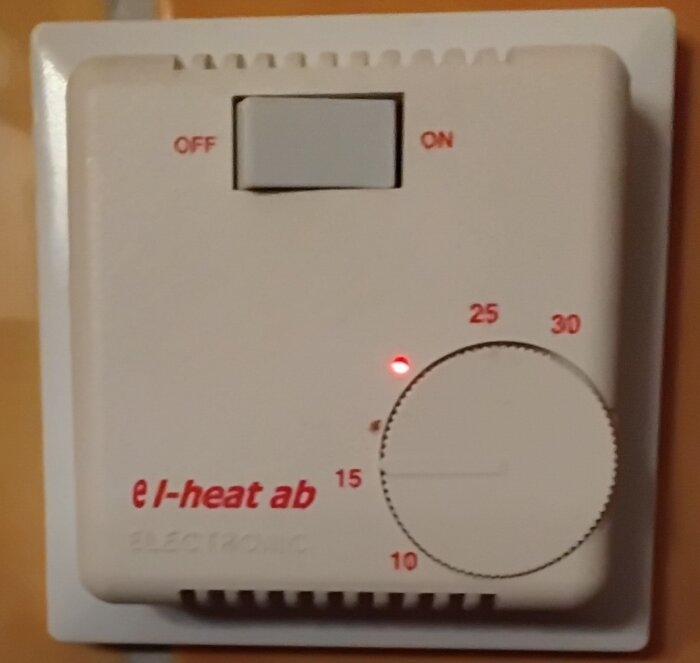 En väggmonterad termostat från e l-heat ab med en reglerbar temperaturinställning mellan 10 och 30 grader och en av/på knapp.