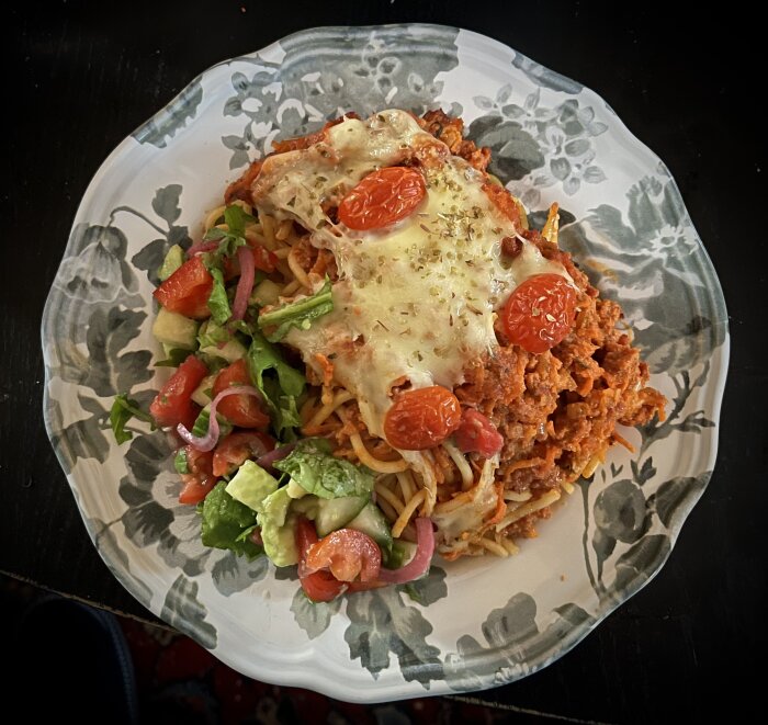 Pastagratäng med ost och tomater, serverad med en sallad innehållande picklad rödlök, vattenmelon och avokado.