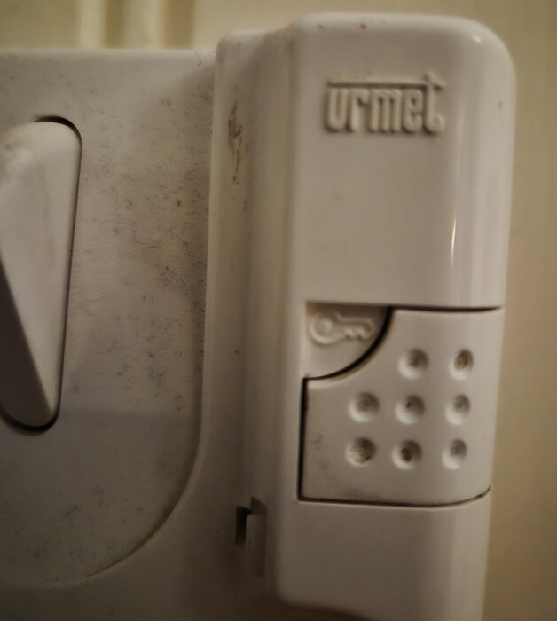 Porttelefon av modell Urmet från 1990-talet med knappar och nyckelsymbol.