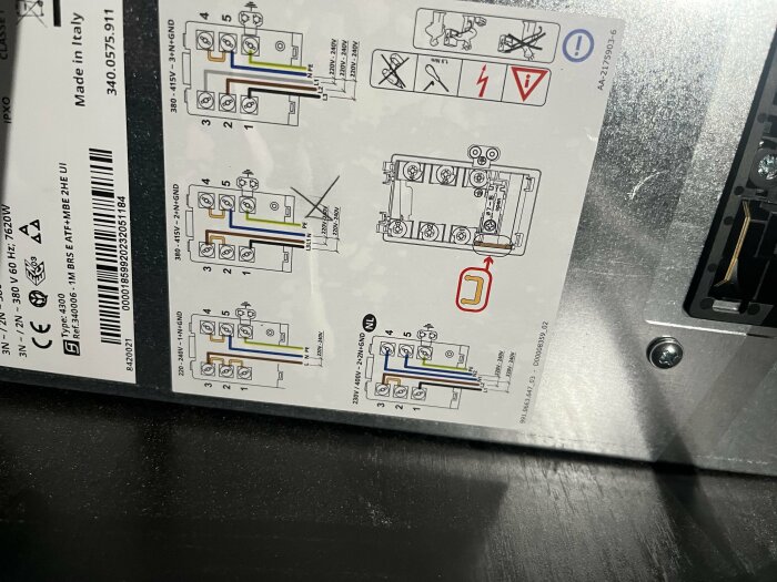 Elkopplingsschema på baksidan av Ikeas spis med integrerad fläkt, markerad med ett kryss och färgkodade kablar.