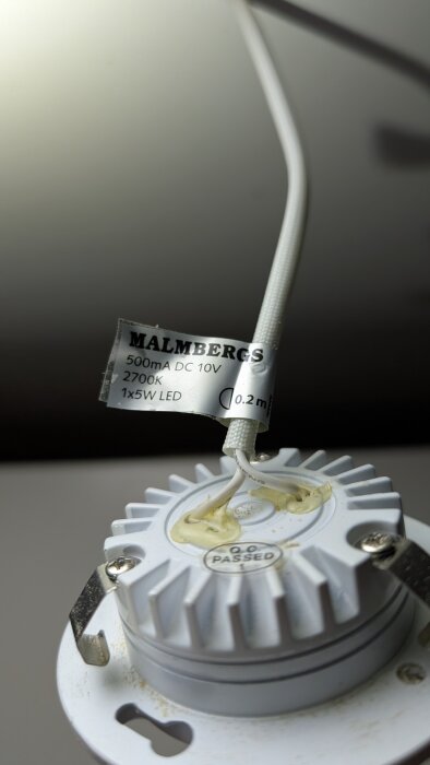 Malmbergs LED-lampa med 500mA DC 10V 2700K specifikationer och certifieringsmärke visas nära en vit kabel.