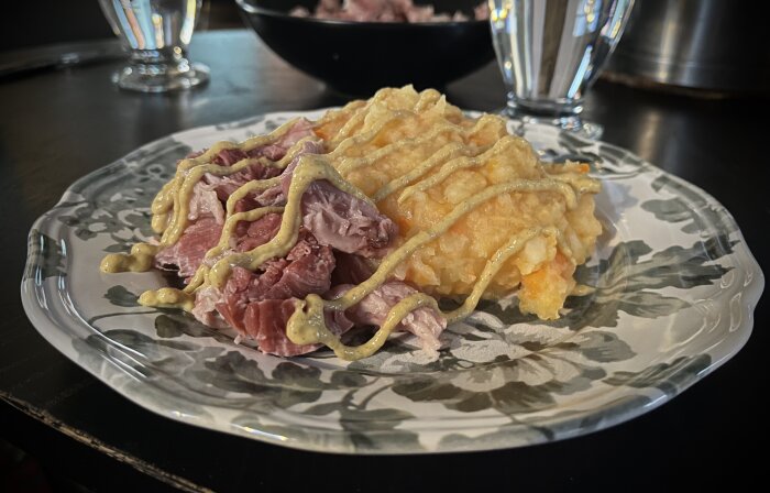 Tallrik med rotmos och fläsklägg, toppat med senap.